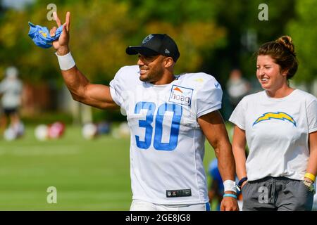 Les Chargers de Los Angeles qui reviennent à Austin Ekeler (30) se font les vagues devant les supporters avec le directeur des communications de l'entreprise Lauren Meyer après le camp d'entraînement sur Mar Banque D'Images