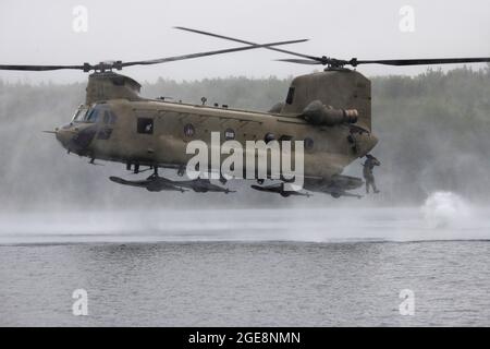 Un ingénieur de combat de l'Armée de terre de la Breacher Company, 6e Brigade Engineer Battalion (Airborne), 4e Brigade de combat d'infanterie (Airborne), 25e division d'infanterie, U.S. Army Alaska, saute d'un CH-47 Chinook pendant l'entraînement d'héliocast à Clunie Lake, base interarmées Elmendorf-Richardson, Alaska, 17 août 2021. Les ingénieurs de combat ont mené les opérations d'hélicast pour établir la confiance et se familiariser avec la formation qu'ils rencontreront lors de leur prochain cours de leadership Sapper. Des aviateurs de l'armée du 2e Bataillon, 211e Régiment d'aviation, de la Garde nationale de l'Armée de l'Alaska, ont fourni un appui aérien pour Banque D'Images