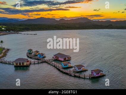 Cottages et docks sur la mer pendant le coucher du soleil dans la baie de Maimon, Puerto Plata, la République dominicaine Banque D'Images