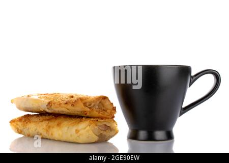 Deux mini strudels aux pommes maison avec une tasse en céramique, en gros plan, isolés sur du blanc. Banque D'Images