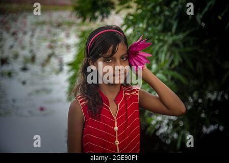 Non exclusif: BARISHAL, BANGLADESH - AOÛT 17: Une fille tient un nénuphar tout en traversant la rivière sur un bateau à Satla Union, dans un k carré de plus de 40 Banque D'Images