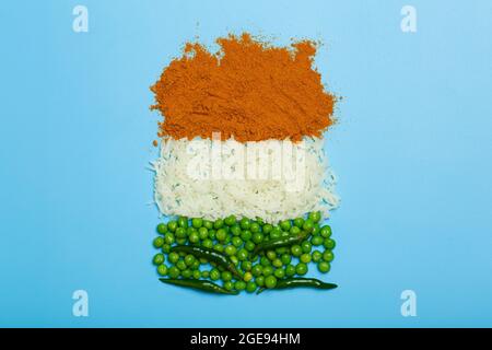 Drapeau indien à base de nourriture. Riz basmati, curry, pois verts et piments aux couleurs du drapeau indien sur fond bleu. Photo de haute qualité Banque D'Images