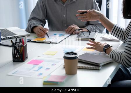 executive Business Women utilise sa main pour expliquer les plans d'affaires avec un homme d'affaires consultant dans les réunions comptables de solutions sur le bureau Banque D'Images
