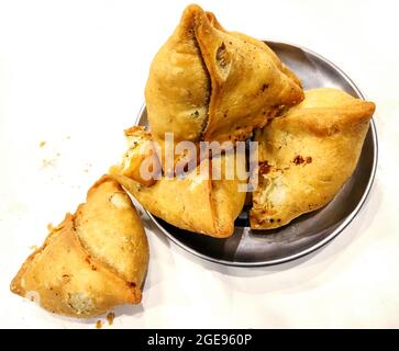 Tapatate samosa sur fond blanc, cuisine traditionnelle indienne ou pakistanaise du ramadan, cuisine de rue Spicy, collations célèbres dans le pays asiatique. Banque D'Images