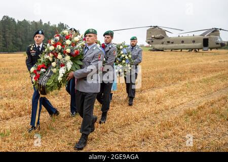 Pegnitz, Allemagne. 18 août 2021. Des soldats américains et allemands ramassent des couronnes dans un hélicoptère de transport Chinook lors d'une commémoration d'un accident d'hélicoptère. Le 18 août 1971, un hélicoptère Chinook de l'armée américaine s'est écrasé près de Pegnitz. 37 soldats ont été tués. C'est le pire accident de l'armée américaine depuis la Seconde Guerre mondiale. Credit: Daniel Karmann/dpa/Alay Live News Banque D'Images