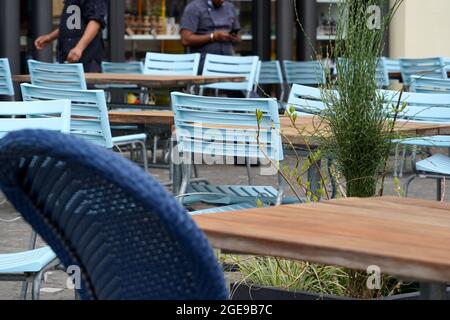 Restaurant extérieur avec tables et chaises vides. En arrière-plan, il y a des serveurs qui attendent les clients. Ville de Lucerne, Suisse. Banque D'Images