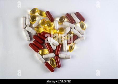 suppléments, pilules arrangées pour ressembler à un coeur, isolé sur blanc Banque D'Images