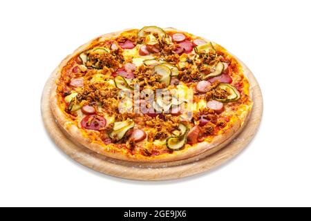 Pizza de type hot dog avec saucisse, oignons rôtis, tranches de concombre marinées et remoulade sur un plateau en bois isolé sur blanc avec passe-cheveux Banque D'Images