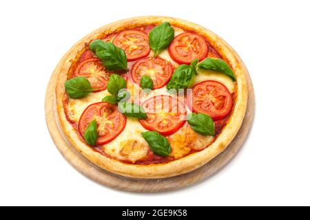 Pizza Margherita avec tranches de tomate, fromage mozzarella et feuilles de basilic frais sur un plateau en bois isolé sur fond blanc Banque D'Images