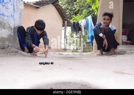 Inde, enfants indiens jouant des marbres dans le village, belle vue sur les sports ruraux Banque D'Images