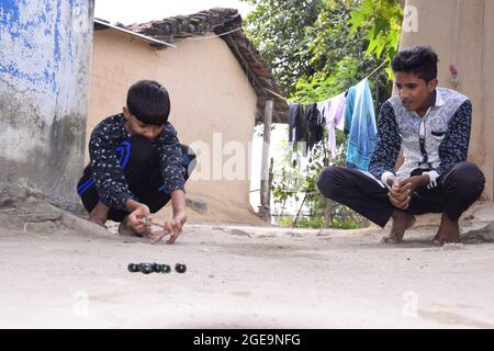 Enfants indiens jouant des marbres dans le village, belle vue sur les sports ruraux Banque D'Images