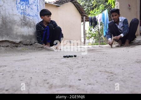 Enfants indiens jouant des marbres dans le village, belle vue sur les sports ruraux Banque D'Images