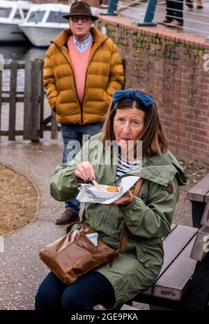 Femme mangeant du poisson et des chips de carton à Norfolk en Angleterre. Banque D'Images