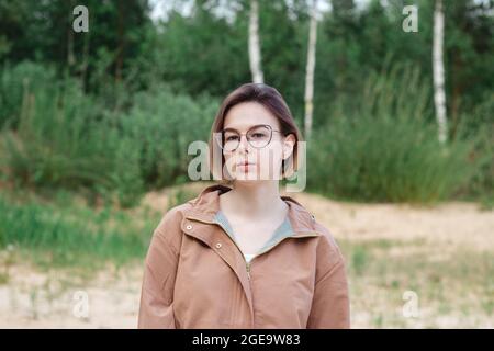Portrait en gros plan d'une jeune femme à cheveux courts dans des lunettes sur la nature Banque D'Images