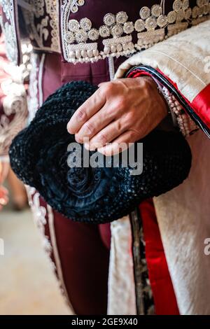 Cachez des taureaux non reconnaissables en costume rouge traditionnel et avec un chapeau montera en préparation de la corrida Banque D'Images