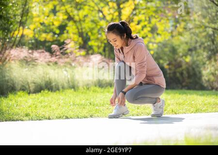 Jeune femme chinoise se préparant à courir le matin dans le parc Banque D'Images