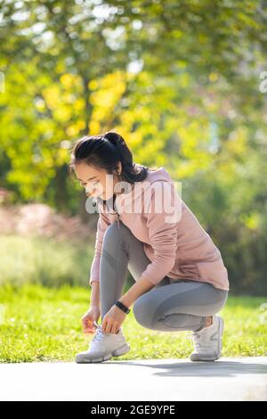 Jeune femme chinoise se préparant à courir le matin dans le parc Banque D'Images