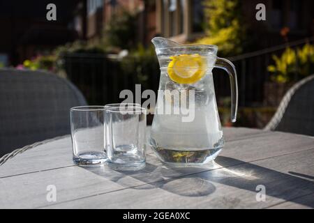 Verseuse d'eau rafraîchissante avec tranches de fruits et deux verres Banque D'Images