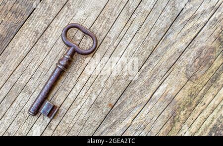 Concept de jeu de la salle d'évasion, ancienne clé en fer vintage sur fond de bois Banque D'Images