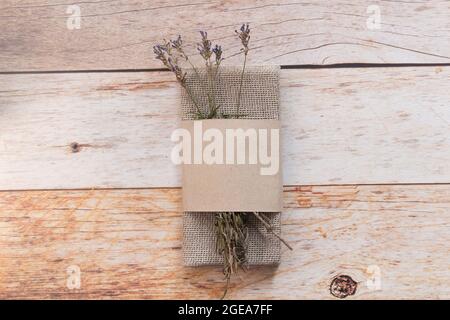 Serviette de table en lin de couleur naturelle pliée et branches de lavande sèches sur une table en bois. Vue de dessus, espace de copie, plan d'affichage, espace pour le texte. Banque D'Images