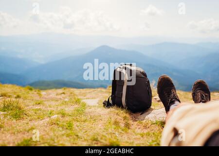 Randonnée dans les montagnes Carpathian. Randonneur se reposant dans un sac à dos tout en profitant du paysage. Voyager en été en Ukraine. Gros plan sur les chaussures de randonnée Banque D'Images