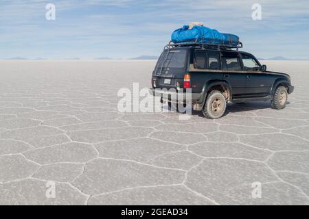 SALAR DE UYUNI, BOLIVIE - 17 AVRIL 2015 : 4X4 avec des touristes au plat salin de Salar de Uyuni, Bolivie Banque D'Images