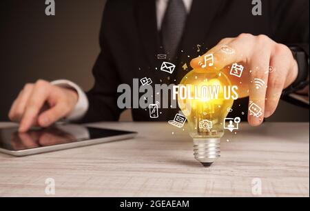 Homme d'affaires tenant une ampoule, concept de médias sociaux Banque D'Images