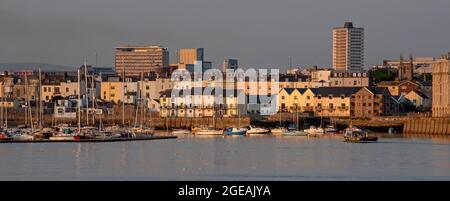 Plymouth, Devon, Angleterre, Royaume-Uni. 2021. Maisons en bord de mer sur la rivière Tamar, Plymouth. Lumière du soir, toile de fond des bâtiments élevés du centre-ville Banque D'Images