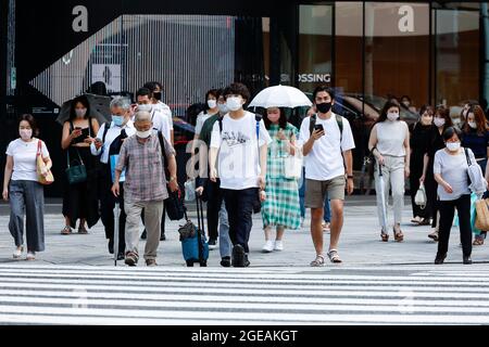 Tokyo, Japon. 18 août 2021. Des piétons portant des masques faciaux marchent dans la zone commerçante de Ginza. Le Gouvernement métropolitain de Tokyo a confirmé mercredi 5,386 nouveaux cas d'infection par le coronavirus dans la capitale. (Credit image: © Rodrigo Reyes Marin/ZUMA Press Wire) Credit: ZUMA Press, Inc./Alamy Live News Banque D'Images