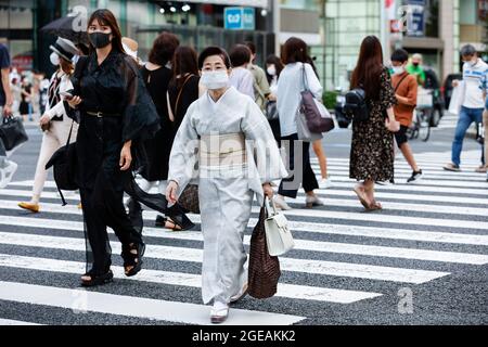 Tokyo, Japon. 18 août 2021. Des piétons portant des masques faciaux marchent dans la zone commerçante de Ginza. Le Gouvernement métropolitain de Tokyo a confirmé mercredi 5,386 nouveaux cas d'infection par le coronavirus dans la capitale. (Credit image: © Rodrigo Reyes Marin/ZUMA Press Wire) Credit: ZUMA Press, Inc./Alamy Live News Banque D'Images