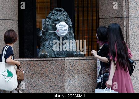 Tokyo, Japon. 18 août 2021. Une statue de lion est vue à l'aide d'un masque facial à l'extérieur d'un centre commercial à Ginza. Le Gouvernement métropolitain de Tokyo a confirmé mercredi 5,386 nouveaux cas d'infection par le coronavirus dans la capitale. (Credit image: © Rodrigo Reyes Marin/ZUMA Press Wire) Credit: ZUMA Press, Inc./Alamy Live News Banque D'Images