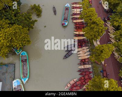 Vue aérienne des constructeurs de bateaux fabriquent des bateaux en bois à "Noukar Haat" (marché de bateaux) à Kuriana sous le Swarupkathi upazila du district de Pirojpur. Le marché de Noukar Haat, d'une longueur de deux kilomètres, est réputé pour le commerce de différentes variétés de bateaux pendant la saison de la mousson. Le marché se déroule tous les vendredis de mai à novembre. “Panis” ou “Pinis”, “Dingi” et “Naak Golui” sont les types de bateaux disponibles à la vente, construits par des artisans locaux des Muktahar, Chami, Boldia, Inderhaat, Boitha Kata, Villages de Dubi et Kathali. Le 18 août 2021 à Barishal, au Bangladesh. Photo de M Banque D'Images