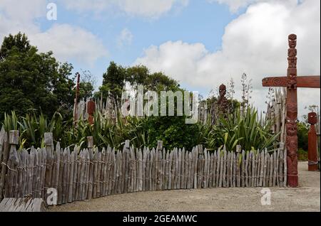 Jardin maori de te Parapara; totems en bois sculpté, clôture en bois, culture indigène, végétation verte, jardins Hamilton; Hamilton, Nouvelle-Zélande Banque D'Images