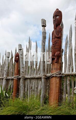 Te Parapara Maori Garden ; totems en bois sculpté, culture indigène, clôture rustique de pantacourts, concassé ensemble, végétation verte, Jardins Hamilton; Hamilton Banque D'Images