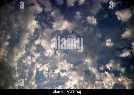 Photo de la composition de petits nuages dans un ciel bleu à la taille au coucher du soleil Banque D'Images