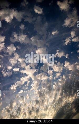 Photo de la composition de petits nuages dans un ciel bleu à la taille au coucher du soleil Banque D'Images