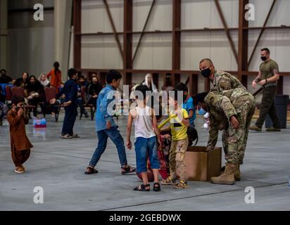 Les membres de la 379e Escadre expéditionnaire aérienne distribuent des jouets aux citoyens afghans dans le cadre de l'opération alliés refuge, le 16 août 2021, à la base aérienne d'Al Udeid, au Qatar. Le ministère de la Défense s'est engagé à appuyer le département d'État des États-Unis dans le départ du personnel civil américain et allié de l'Afghanistan, et à évacuer les alliés afghans en toute sécurité. (É.-U. Photo de la Force aérienne par Airman 1ère classe Kylie Barrow) Banque D'Images