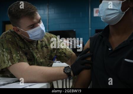 SPC. Kirkland Schramm, un medic de combat avec la Division des troupes spéciales Bataillon MEDOPS, 3e Division Brigade de soutien, administrer le vaccin Moderna COVID-19 à un entrepreneur civil au Camp Arifjan, Koweït, août 17. Les médecins du camp Arifjan ont organisé une campagne de vaccination contre le COVID-19 pour le personnel qui n'est pas entièrement vacciné. (É.-U. Photo de l'armée Sgt. Marquis Hopkins) Banque D'Images