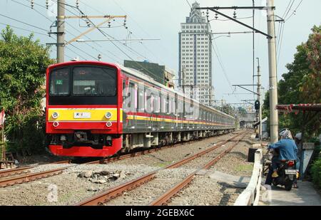 Jakarta, Indonésie-16 août 2021 : motocycliste attendant que le train passe avant de traverser les voies ferrées Banque D'Images