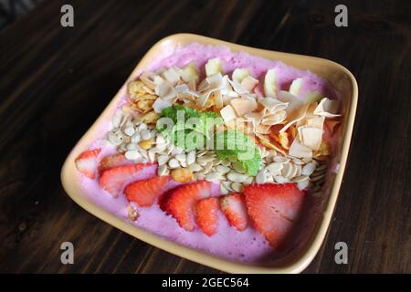 La glace à la noix de coco rasée rose clair est un régal d'été dans la cour au Vietnam pour goûter la douceur de la noix de coco râpée et faire un pique-nique. Banque D'Images