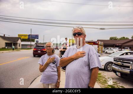 Bloomington, États-Unis. 18 août 2021. Les spectateurs de la rue W. Morgan paient leurs respects lors de la procession funéraire du ambulancier Brandon Staley à Spencer, Indiana. Staley est mort d'une crise cardiaque alors qu'il travaillait comme ambulancier pour le EMS du comté d'Owen (Emergency Medical Services). Staley venait de répondre à un accident de véhicule et était dans une ambulance avec des survivants de l'accident les aidant sur le chemin d'un hôpital quand il lui-même est tombé malade. Crédit : SOPA Images Limited/Alamy Live News Banque D'Images