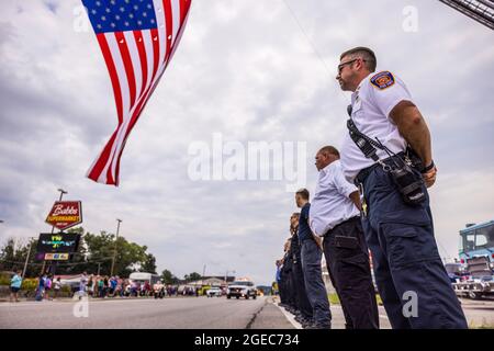 Bloomington, États-Unis. 18 août 2021. Un drapeau américain survole W. Morgan Street lors d'un cortège funéraire pour le ambulancier décédé Brandon Staley à Spencer, Indiana. Staley est mort d'une crise cardiaque alors qu'il travaillait comme ambulancier pour le service EMS du comté d'Owen (Emergency Medical Services). Staley venait de répondre à un accident de véhicule et était dans une ambulance avec des survivants de l'accident les aidant sur le chemin d'un hôpital quand il lui-même est tombé malade. (Photo de Jeremy Hogan/SOPA Images/Sipa USA) crédit: SIPA USA/Alay Live News Banque D'Images