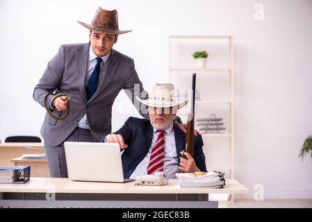 Deux employés de cow-boy dans un concept drôle Banque D'Images