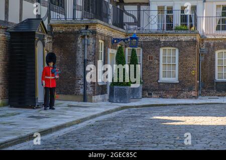 Idée de Staycation. Garde-corps Coldstream en robe militaire tenant un fusil posté à la boîte de garde devant la maison de la Reine à la Tour de Londres. Banque D'Images