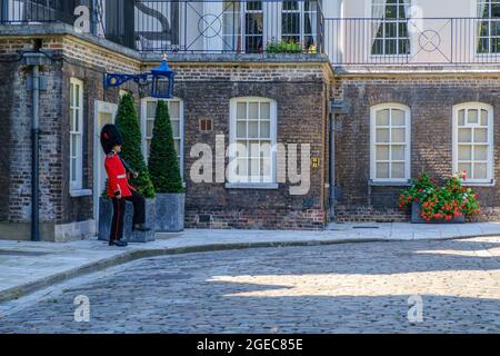 Idée de Staycation. Coldstream Guards sentinelle en robe militaire tenant un fusil et marchant devant la maison de la Reine à la Tour de Londres, Royaume-Uni. Banque D'Images