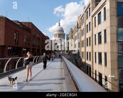 Londres, Grand Londres, Angleterre, août 10 2021 : une femme avec un chien en laisse sur le pont du Millénaire avec la cathédrale St Pauls derrière. Banque D'Images