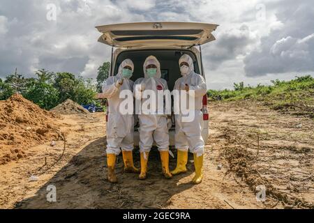 Kendari, Indonésie. 18 août 2021. Les travailleurs de la santé vêtus de combinaisons protectrices posent pour une photo après l'inhumation des victimes de Covid-19.le processus funéraire pour les patients de Covid-19 ayant des protocoles de santé est effectué par des agents de santé hospitaliers à Kendari. Bien que le nombre de patients traités par COVID-19 diminue, le taux de mortalité est constant chaque jour. Crédit : SOPA Images Limited/Alamy Live News Banque D'Images