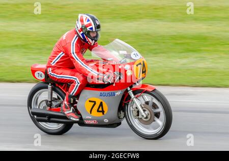 Phil Read's 1974 MV Agusta 500 Motorcycle course en haut de la piste de montée de colline à l'événement de course automobile de Goodwood Festival of Speed 2014. Banque D'Images