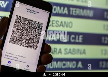 Rome, Italie. 29 juillet 2021. Rome, Italie, jeudi 29 juillet 2021. Certificat numérique Covid de l'UE Green Pass sur un téléphone portable tenu devant un train Banque D'Images