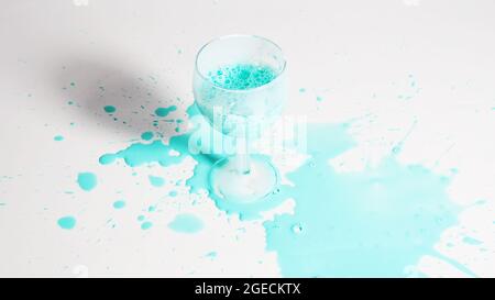 Verre avec liquide de menthe renversé sur un fond blanc. Banque D'Images